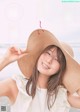 A woman wearing a straw hat on the beach.