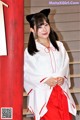 A woman in a white and red kimono posing for a picture.