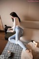 A woman sitting on a couch using a laptop computer.