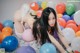 A woman laying on the floor surrounded by balloons.