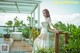 A woman in a white dress standing on a balcony.