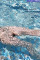 A person swimming in a pool with clear water.