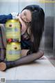 A woman sitting on the floor next to a can of beer.