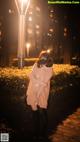 A woman wearing a face mask standing on a boardwalk at night.