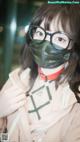 A woman wearing a green mask and glasses.