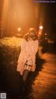 A woman wearing a face mask standing on a boardwalk at night.