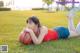 A woman laying on the grass with a basketball.