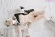 A woman laying on top of a bed in a maid outfit.