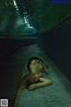 A woman laying on the ground in a tunnel.