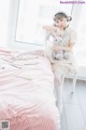 A woman sitting on a bed holding a stuffed animal.