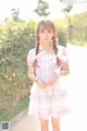 A young woman in a purple and white dress posing for a picture.